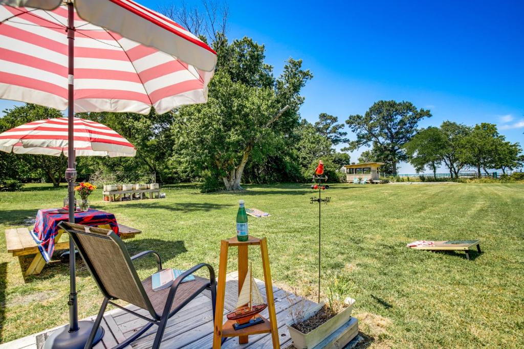 a deck with a chair and an umbrella and a table at Maryland Retreat Walk to Bay, Beach and Boat Ramp! in Deal Island
