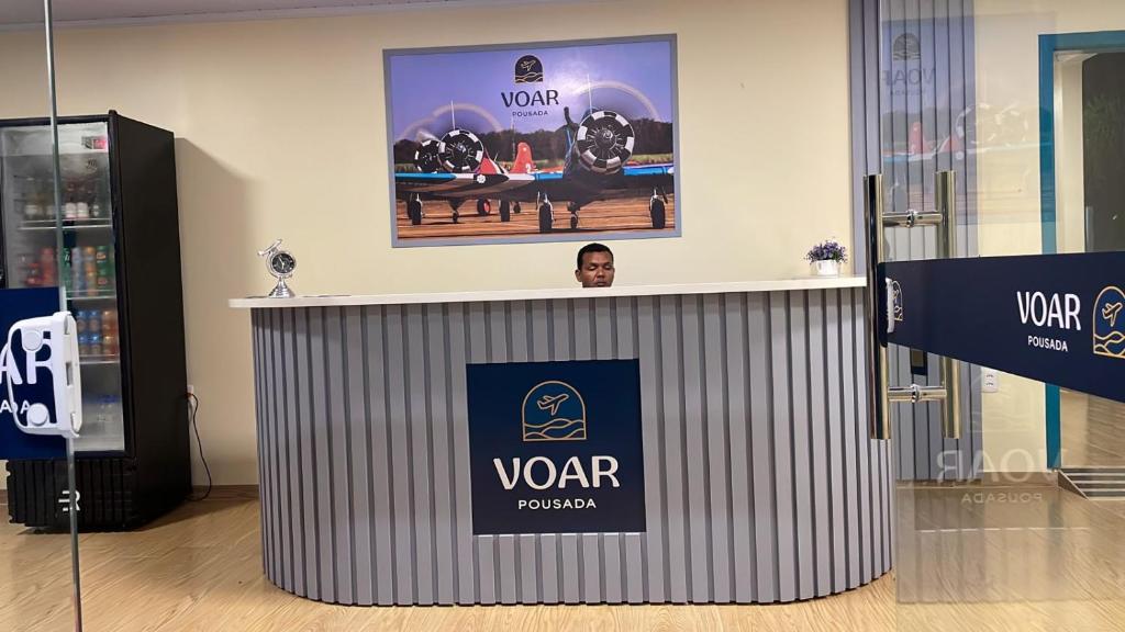 a man is standing behind a podium in a room at Voar Pousada in Barreirinhas