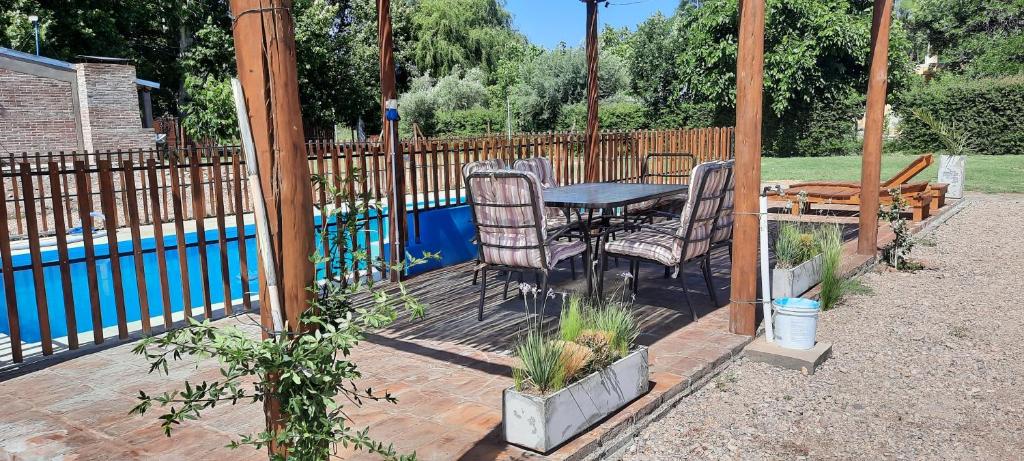 Un patio con mesa y sillas junto a una piscina. en El Nevado Casa de Campo 1, en San Rafael