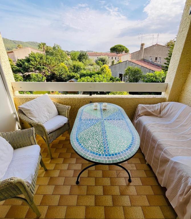 un balcon avec une table et des chaises et une vue dans l'établissement Entre mer et colline l'Escale Provençale ., à Saint-Cyr-sur-Mer