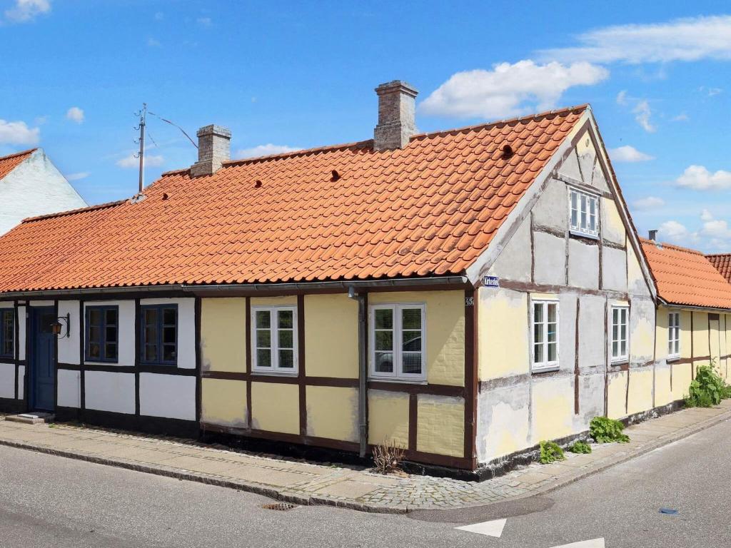 Nystedにある4 person holiday home in Nysted-By Traumの通り沿いのオレンジ色の屋根の古家