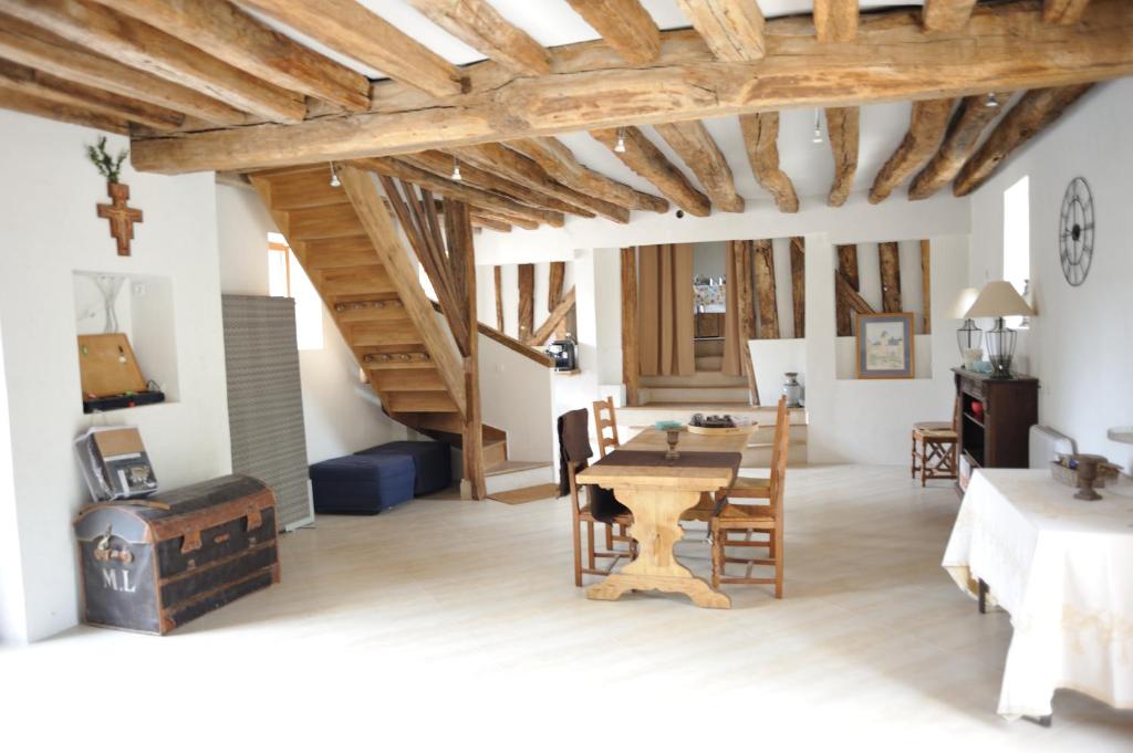 a living room with a wooden table and chairs at La Bergerie Du Château De Pommeuse in Pommeuse