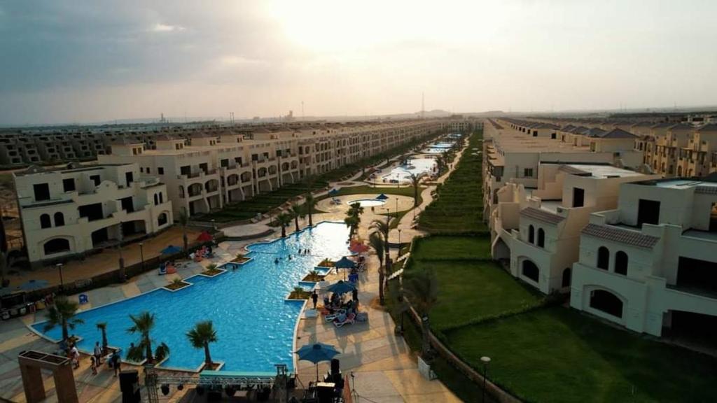 une grande piscine dans une ville avec des immeubles dans l'établissement Laserina palme beach resort, à Ain Sokhna