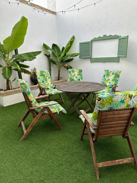 a table and two chairs and a table with grass at Casa en el centro de Arahal in El Arahal