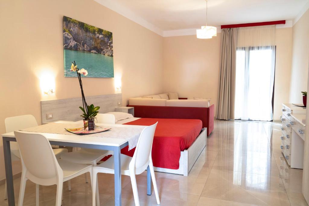 a room with a bed and a dining table and a bedroom at Residence Cilento in Marina di Camerota