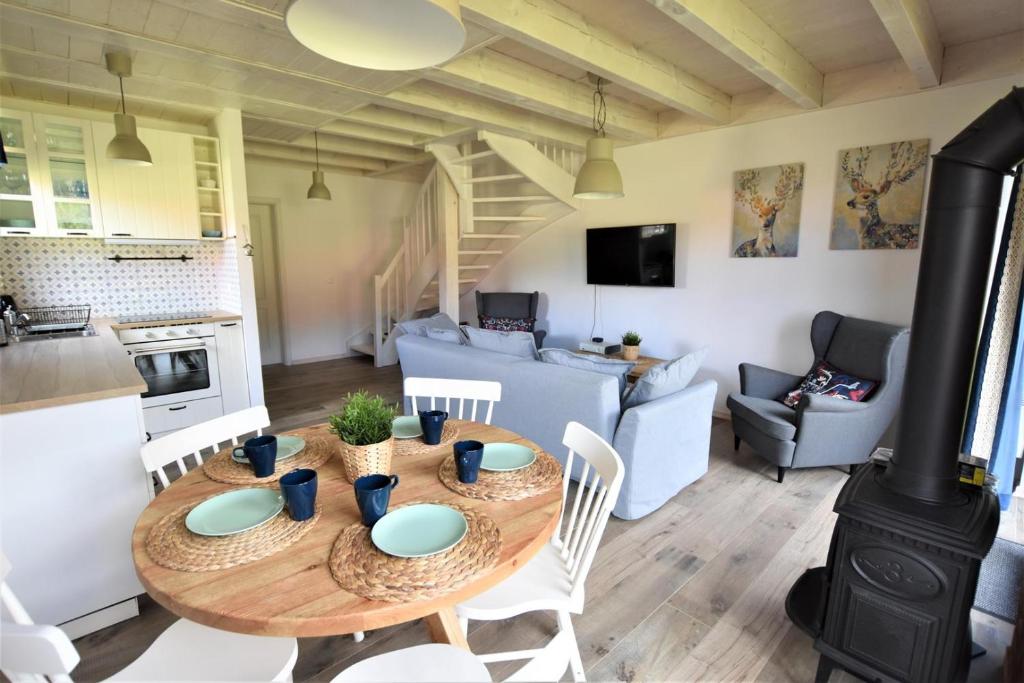 una cucina e un soggiorno con tavolo e sedie di Domek na Kaszubach 19-1 - Ostoja Bukowo a Borowy Młyn