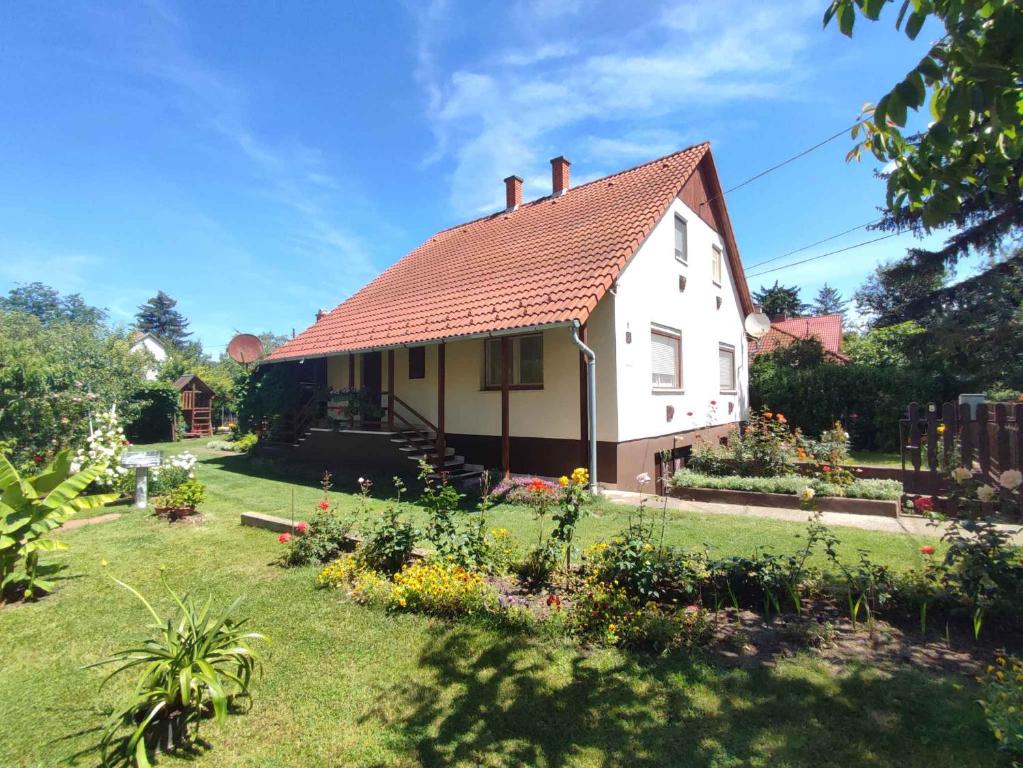 a white house with a red roof and a yard at Holiday home in Agard - Velence-See 51093 in Agárd