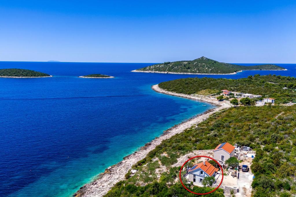 eine Luftansicht eines Hauses auf einer Insel im Ozean in der Unterkunft Seaside house for families with children Cove Ramascica, Trogir - 23368 in Marina