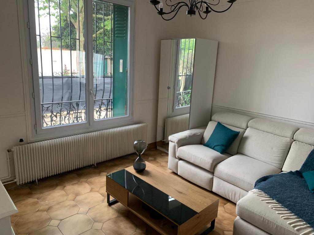 un salon avec un canapé et une table basse dans l'établissement Pierre meulières, à Colombes