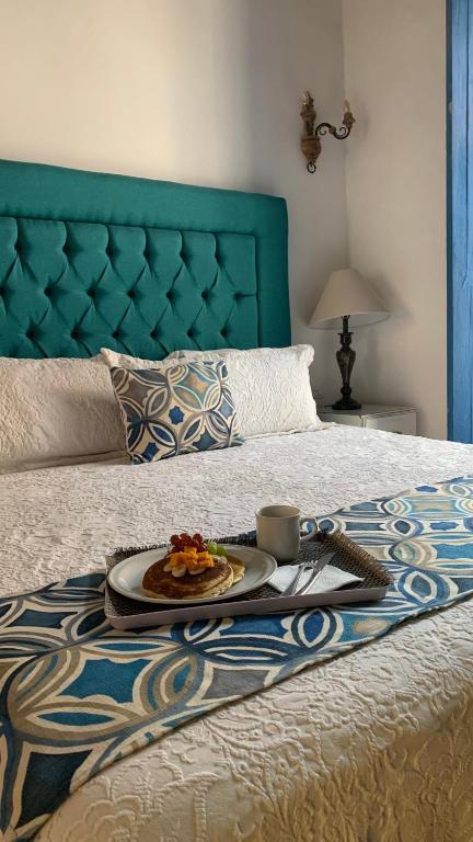 a tray with a plate of food on a bed at Alonso53 in Guanajuato