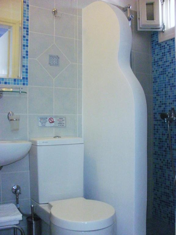 a bathroom with a white toilet and a sink at Blue Harmony Apartments in Plaka