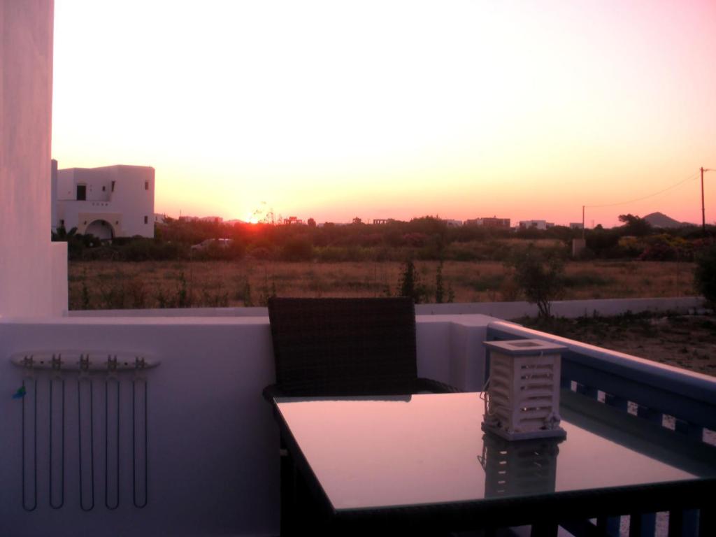 a laptop on a balcony with the sunset in the background at Blue Harmony Apartments in Plaka