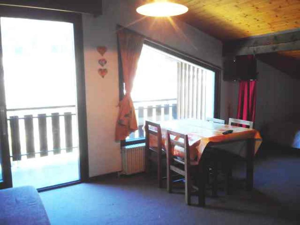 Cette chambre dispose d'une table, de chaises et d'un balcon. dans l'établissement Studio confortable, vue sur Morzine, balcon, WIFI, parking - FR-1-524-26, à Morzine