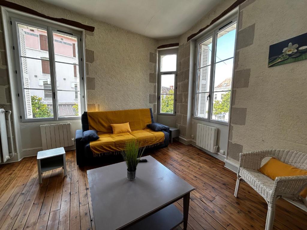 un salon avec un canapé et une table dans l'établissement Charmant T2 en centre-ville, 1er étage, La Roche-Posay, pour 4 pers, animaux bienvenus - FR-1-541-107, à La Roche-Posay
