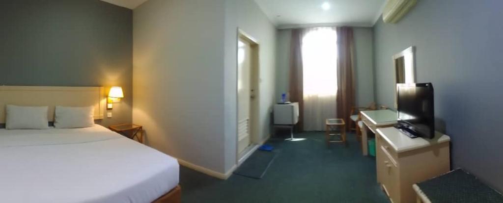 Postel nebo postele na pokoji v ubytování Sandakan Inn