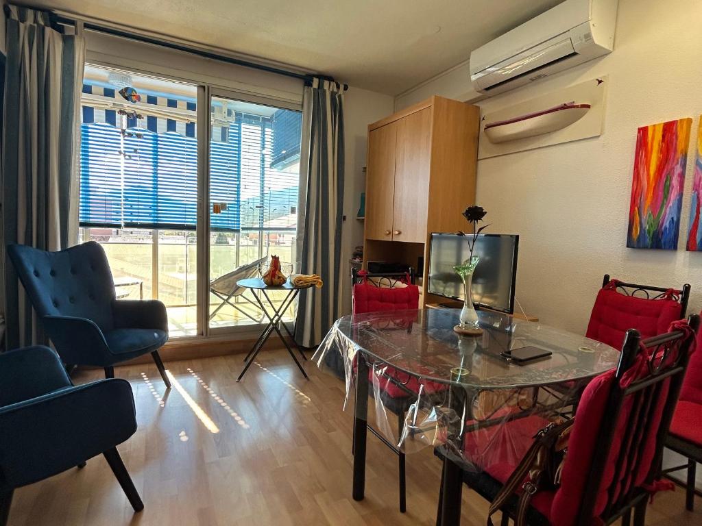 un salon avec une table en verre et des chaises dans l'établissement Studio climatisé à 300m de la plage avec parking et terrasse - Argelès-sur-Mer - FR-1-732-84, à Argelès-sur-Mer