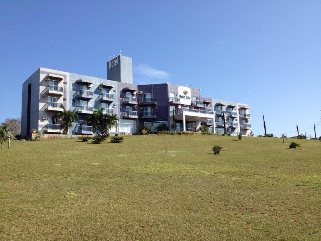 un grand bâtiment avec une pelouse devant lui dans l'établissement Hotel Cedro Palace, à São José do Cedro