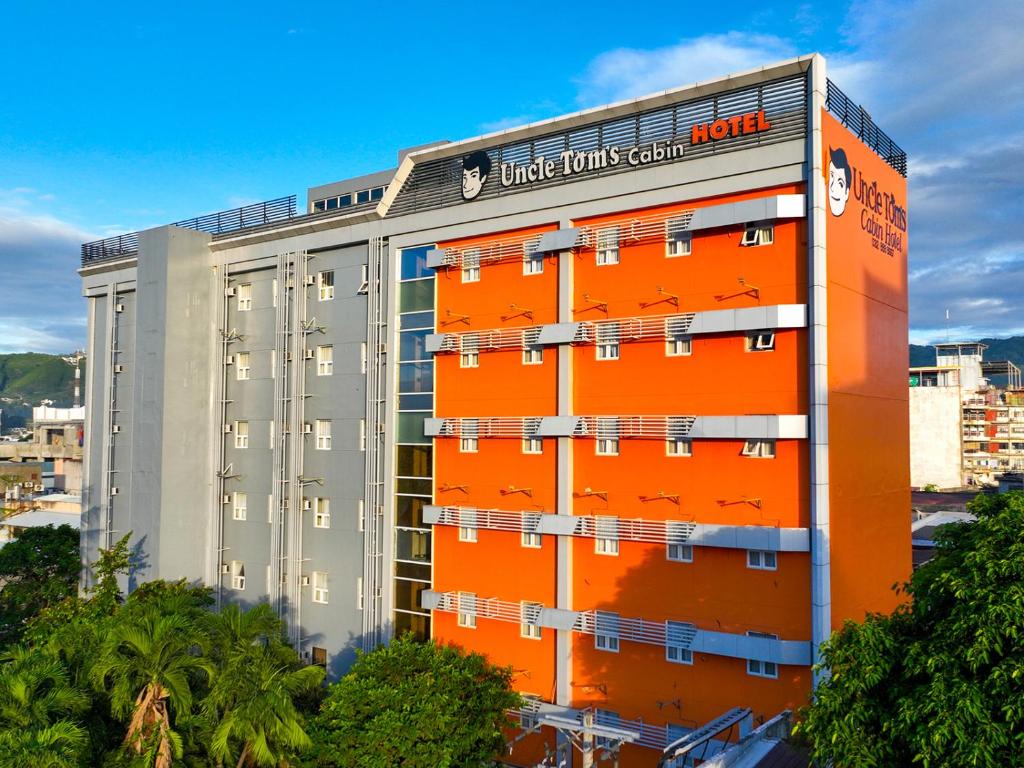 a hotel building with orange paint on it at Tom's Cabin Hotel in Cebu City