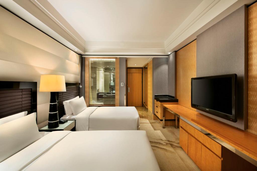 a hotel room with two beds and a flat screen tv at Crowne Plaza Chengdu City Center by IHG in Chengdu