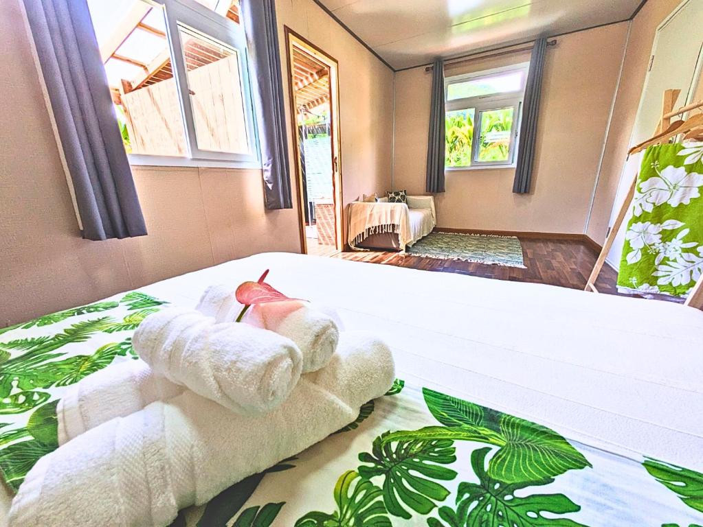 una stanza con un letto con asciugamani sopra di Natura OM Teahupoo surf lodge a Toanoano