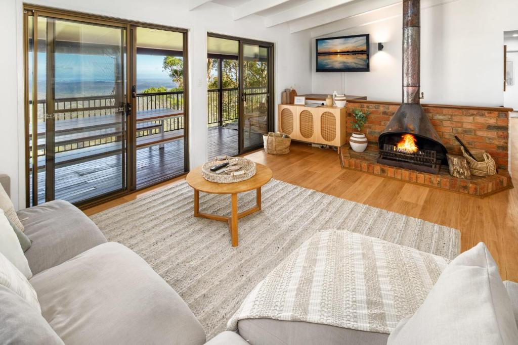 a living room with a couch and a fireplace at Montville Retreat With Hinterland & Coastal Views in Montville