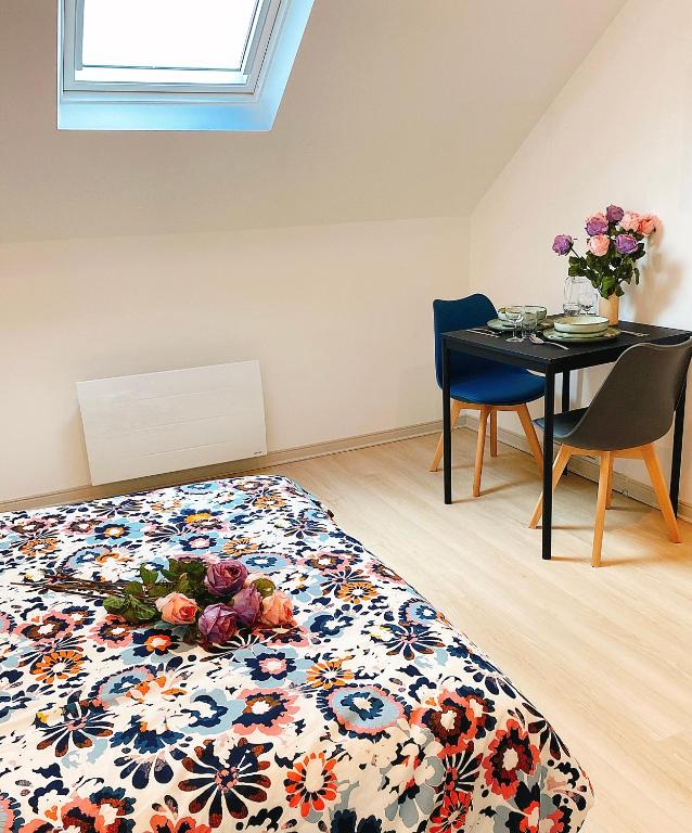 - une chambre avec un lit et une table fleurie dans l'établissement Pacello studio, à Amboise