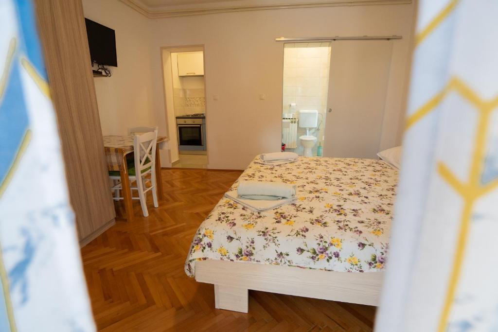 a small bedroom with a bed and a kitchen at Apartmani Vidušin in Novalja