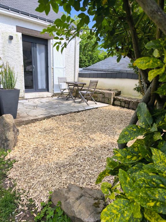 a patio with two chairs and a table in front of a house at Plouharnel-Carnac-Quiberon bord de mer in Plouharnel