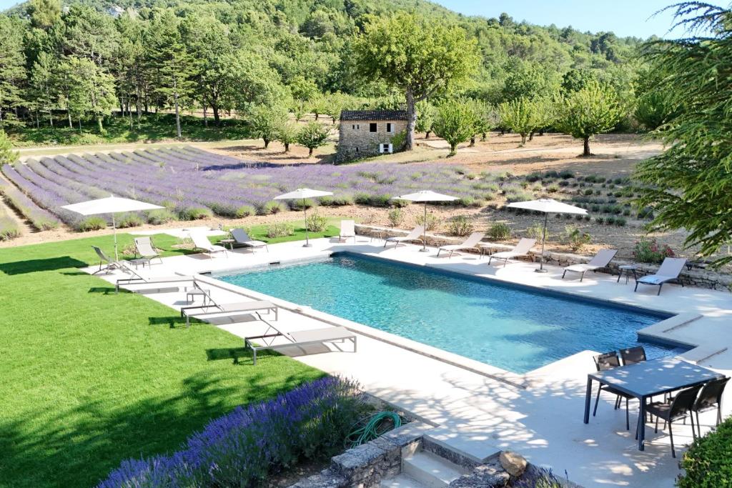 une image d'une piscine avec des chaises et une table dans l'établissement Bastide de l'Esclat - swimming pool - 9 rooms - 17 pers, à Apt