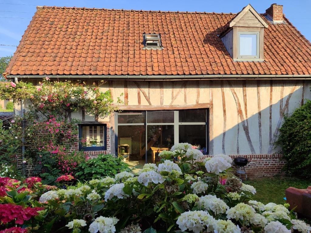 a house with a garden of flowers in front of it at la grange Saint Georges in Hermaville