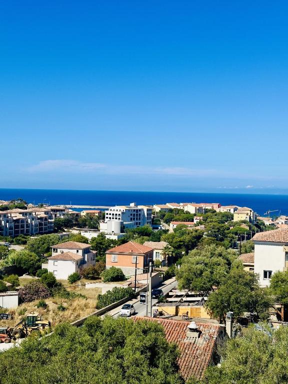 Vue sur une ville avec l'océan en arrière-plan dans l'établissement Magnifique 2 pièces vue mer, à LʼÎle-Rousse