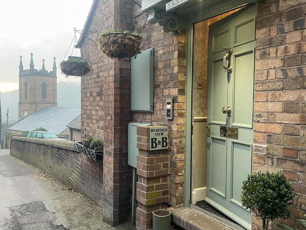 a brick house with a bbb sign next to a door at Heritage View Guest House in Ironbridge