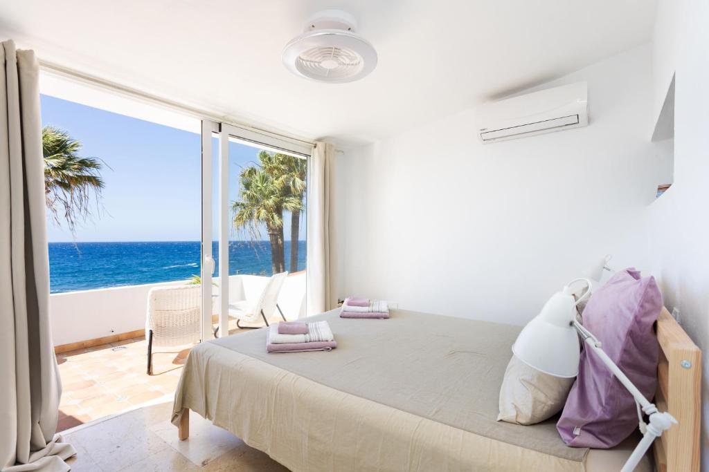 a bedroom with a bed with a view of the ocean at Casita Seafront Oasis del Sur in San Miguel de Abona