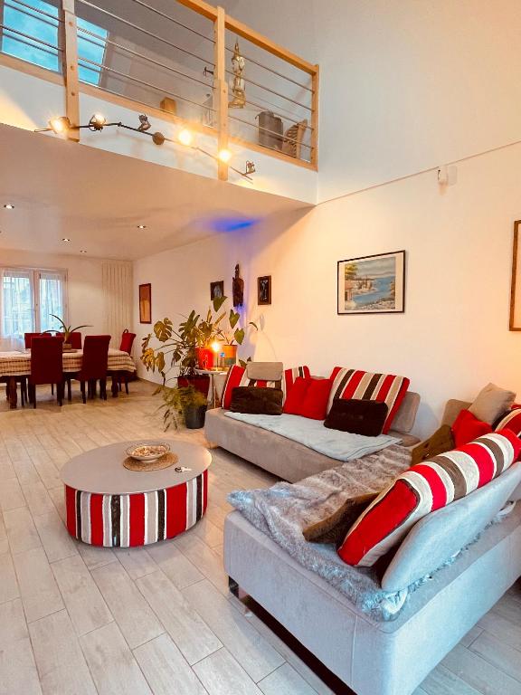 un salon avec deux canapés et une table dans l'établissement Maison Calme et Confort avec Jardin, Face Parc Exposition - Aéroport du Bourget, à 10 min de CDG, au Blanc-Mesnil