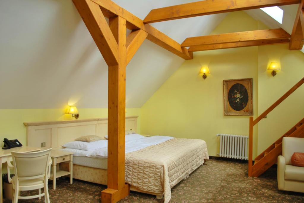a bedroom with a bed and a desk in a room at Hotel Metamorphis in Prague