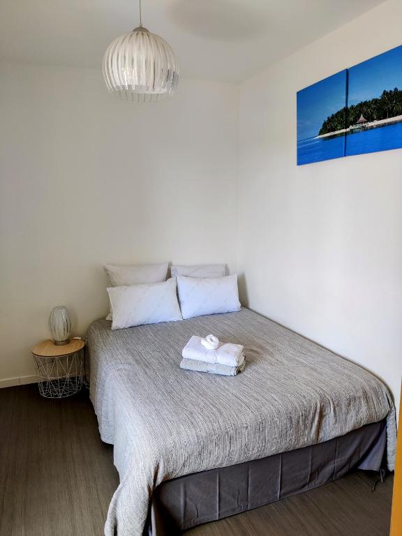 une chambre avec un lit avec une serviette dessus dans l'établissement Spacieux appartement refait à NEUF - 4 pers - vue sur l'hippodrome, à Cabourg