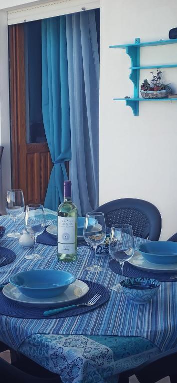 a table with a bottle of wine and glasses on it at HAIKU HOME in Cala Gonone