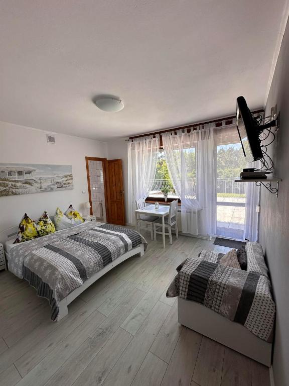 a bedroom with two beds and a desk in it at Jarek in Pobierowo