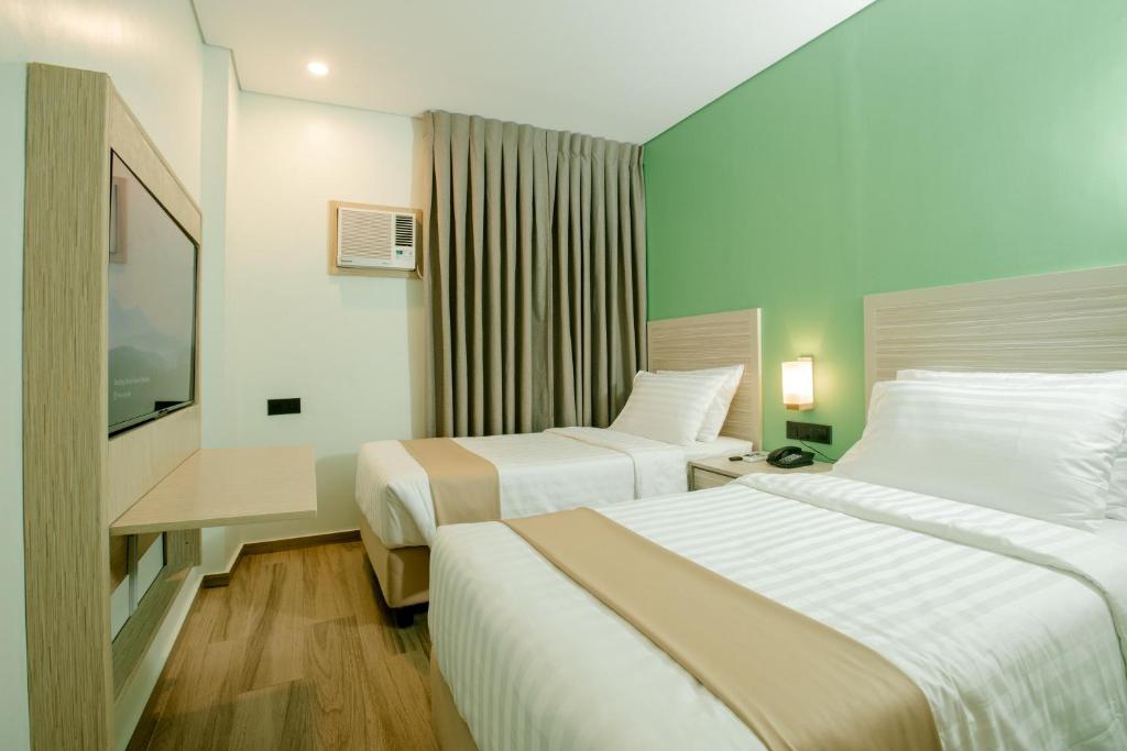Postel nebo postele na pokoji v ubytování Hamersons Hotel CDO