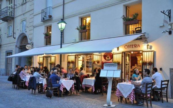 grupa ludzi siedzących przy stolikach przed restauracją w obiekcie Guest House - Il Cedro Reale w mieście Venaria Reale