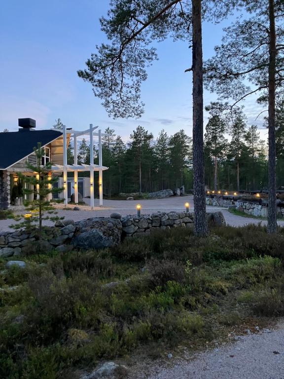 a house in the woods at night with lights at HUNURIJÄRVI RESORT***** in Härmä