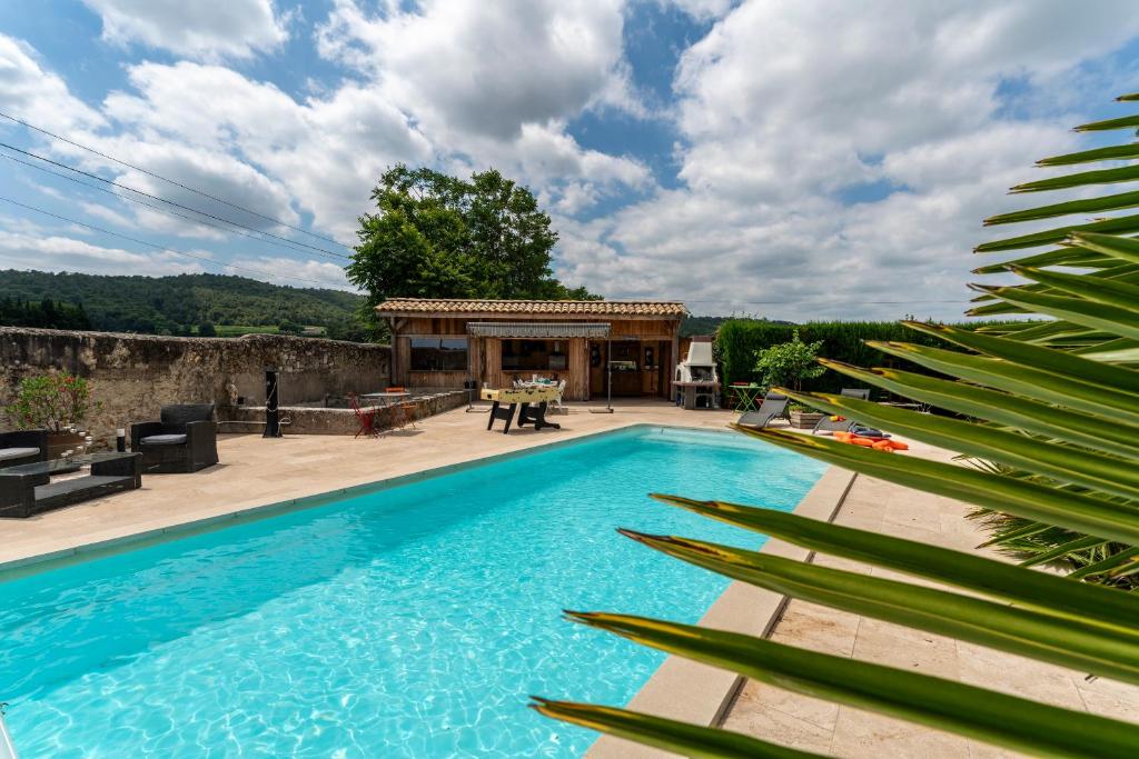 a swimming pool with a patio and a house at Mas de la Tontine in Pont-Saint-Esprit
