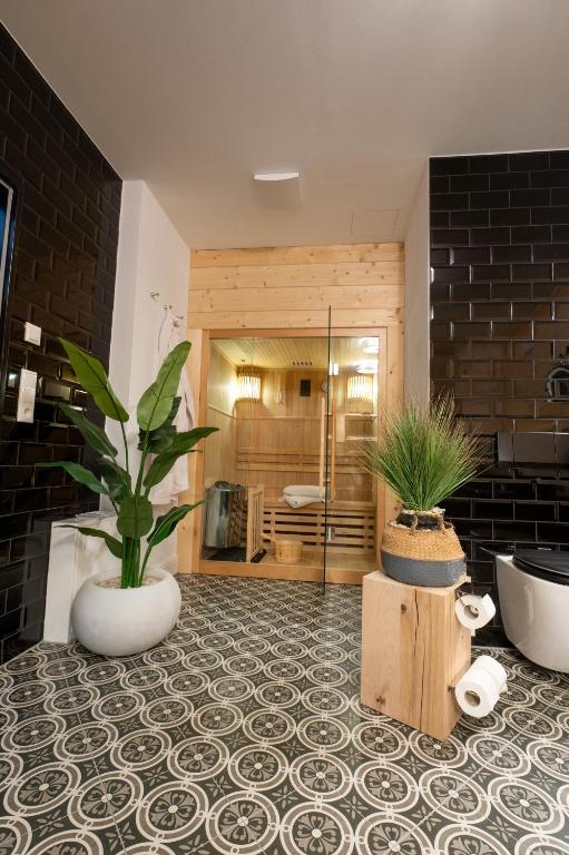 a bathroom with a potted plant on a tile floor at ALPENLIEBE - Sauna & Whirlpool - APARTments in Inzell
