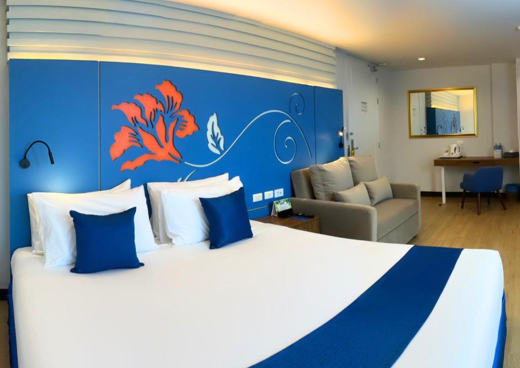 a bedroom with a large bed with a blue wall at Days Inn by Wyndham Patong Beach in Patong Beach