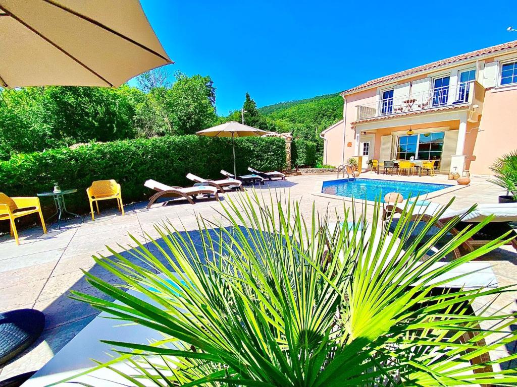 a patio with a pool and chairs and a building at Villa Venus Privacy & Relax in Mošćenička Draga