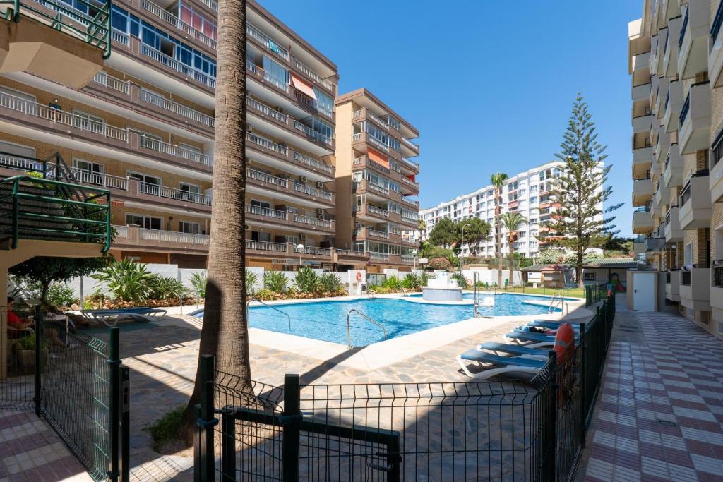 a swimming pool with lounge chairs next to a building at Ronda IV - Best Location Apartment in Las Lagunas Mijas