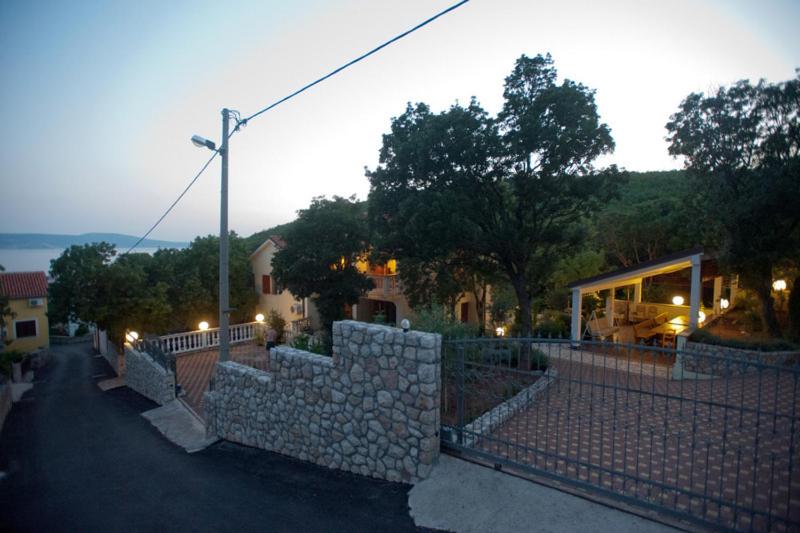 a house with a stone wall and a fence at Apartments Marinko in Povile