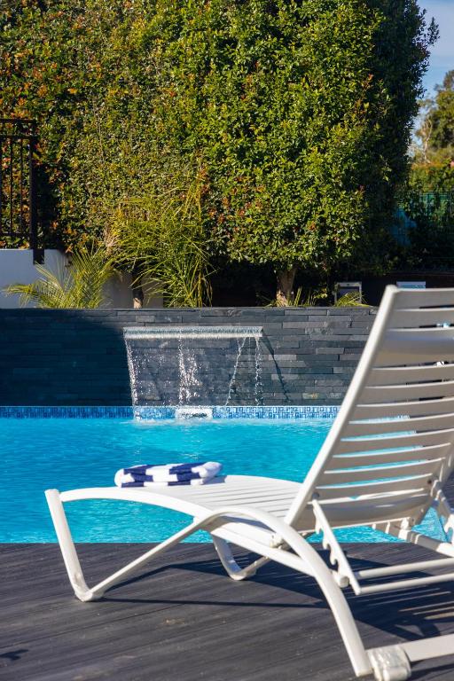 a white lounge chair sitting next to a swimming pool at Cloverleigh Guest House in Wilderness