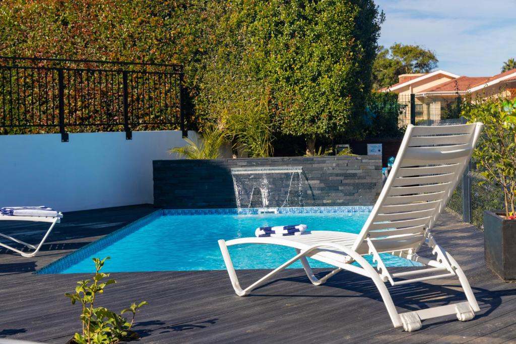 a white chair sitting next to a swimming pool at Cloverleigh Guest House in Wilderness
