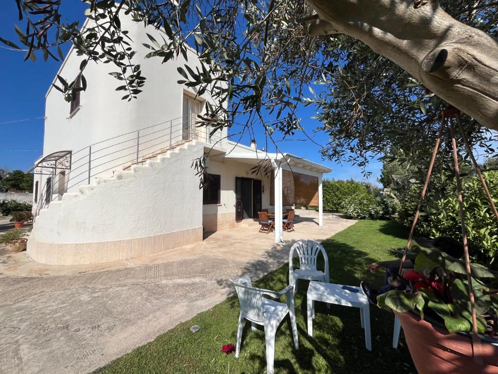 a view of a house with two chairs in the yard at Coco' Country House Lecce in Lecce